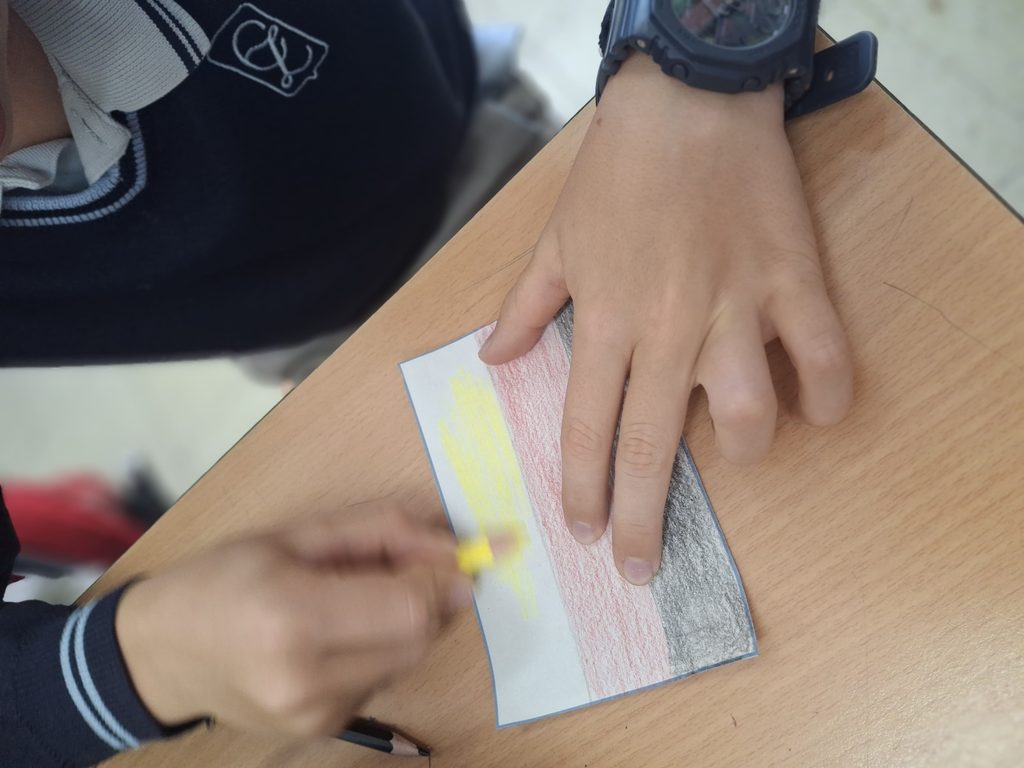 Alumno del colegio Zola pintando una bandera de Alemania